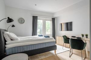 a bedroom with a bed and a desk and a window at Brand new apartment - Minerva in Turku