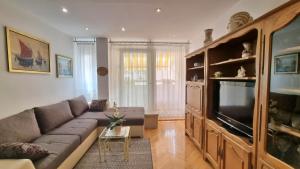 a living room with a couch and a flat screen tv at Apartment Maja in Omiš