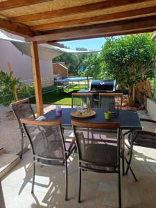 a patio with a table and chairs under a pergola at Kuća za odmor L&L in Bibinje
