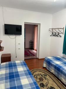 a room with two beds and a flat screen tv at Абия in Cholpon-Ata +7 photos