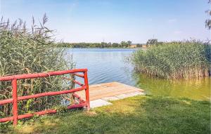 a red bench sitting on the side of a lake at Holiday Home Moscienica Moscienicka Ii in Kórnik