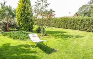 a chair sitting in the grass in a yard at Holiday Home Moscienica Moscienicka Ii in Kórnik +11 photos