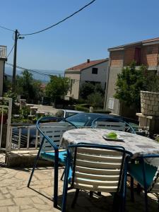 a table with two chairs and a table and a table and chairs at Apartman Zora in Neum