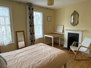 a bedroom with a bed and a desk and a mirror at Victorian Period Central Home in Cambridge