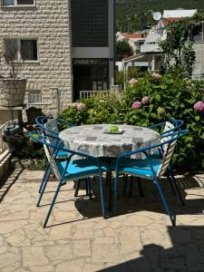 a table and chairs on a patio with flowers at Apartman Zora in Neum +5 photos