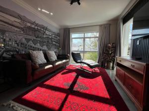 a living room with a couch and a red rug at Salt Air & Serenity, Relaxing Ocean Escape in Cape Town +15 photos