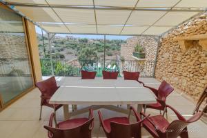 a dining room with a table and chairs on a balcony at Dar Tat Tork in Xagħra