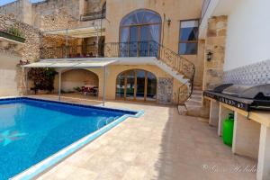 una casa con piscina y un edificio en Dar Tat Tork, en Xagħra