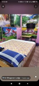 a bed in a room with paintings on the wall at Sri bagavan lodge in Tiruvannāmalai