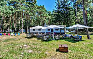 a group of tables and chairs under umbrellas at Beautiful Home In Sulnowo With Sauna in Sulnówko