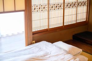 尾道市1棟貸切宿 木曽家旅館 しまなみ海道最初の島 supported by COCOSTAY的有窗户的房间里的一张床