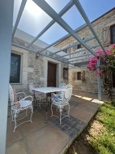 a patio with a table and chairs on it at Eski Datça Otel in Datca