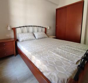 a bedroom with a large bed and a wooden cabinet at Apartments Bella Casa in Paralia Katerinis