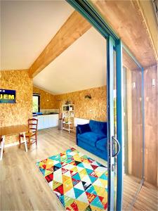 a living room with a blue couch and a colorful rug at Bienvenue moto vélo lanquais varennes in Varennes