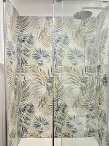 a shower curtain with a pattern of leaves on a wall at Sempre di Domenica in Santo Spirito +11 photos