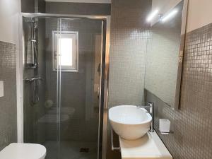 un bagno con doccia, lavandino e WC di Case di Torre Pali a Torre Pali