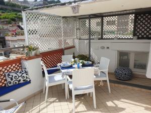 a patio with a table and chairs and a fireplace at Donna Rosa Capri - Charming House by the Sea in Capri