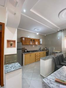 a large kitchen with wooden cabinets and counter tops at Appartement proche de la corniche in Al Hoceïma +5 photos