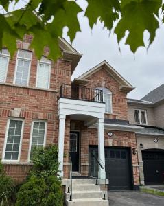 a brick house with a balcony on it at Modern Detached Home in the Suburbs of Toronto in Ajax +34 photos