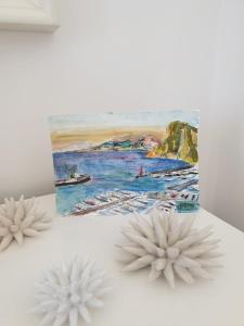 a painting and two white flowers on a table at Donna Rosa Capri - Charming House by the Sea in Capri