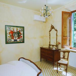 a bedroom with a bed and a dresser and a mirror at Villa Lulli affittacamere in Sansepolcro