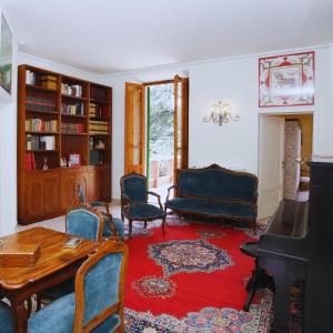 a living room with a table and chairs and a piano at Villa Lulli affittacamere in Sansepolcro