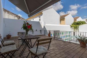 um pátio com uma mesa e cadeiras e uma cerca em Apartamentos Casa Rosaleda em Jerez de la Frontera