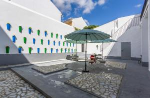 um pátio com uma mesa e um guarda-chuva em frente a um edifício em Apartamentos Casa Rosaleda em Jerez de la Frontera mais 83 fotografias