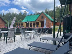 a patio with tables and chairs and a building at Chybotek Premium Domek Danusia in Przesieka
