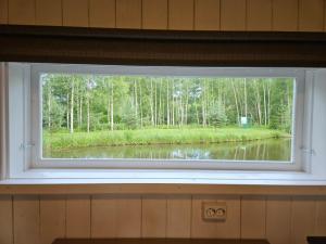 a window in a room with a view of a lake at Purde Camp Cabin in Elva