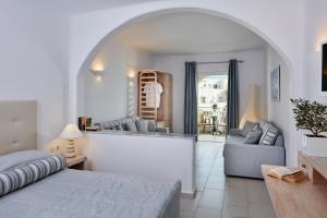 a bedroom with a bed and a couch and a mirror at Aegean Plaza Hotel in Kamari +18 photos