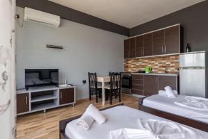 a room with two beds and a kitchen with a tv at Denis Apartments in Sarandë +52 photos