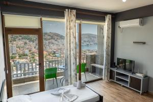 a bedroom with a bed and a balcony with a view at Denis Apartments in Sarandë