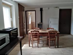 a dining room with a wooden table and chairs at Studio d'antan in Orpierre