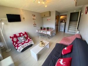 Appartement Résidence Cortina3 في بوي-سانت-فينسينت: غرفة معيشة مع أريكة زرقاء وطاولة +4 صور