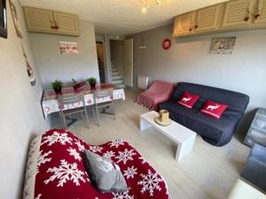 Appartement Résidence Cortina3 في بوي-سانت-فينسينت: غرفة معيشة بها أريكة وطاولة