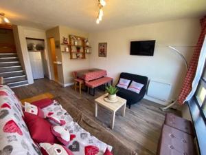 Appartement Résidence Cortina3 في بوي-سانت-فينسينت: غرفة معيشة بها أريكة وطاولة