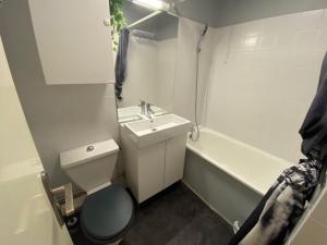 Appartement Résidence Cortina3 في بوي-سانت-فينسينت: حمام مع مرحاض ومغسلة وحوض استحمام