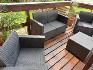 two wicker chairs and a table on a deck at Haus Piller in Bad Hofgastein