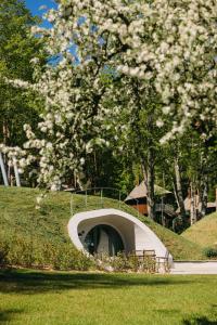 a tunnel in the middle of a park with a tree at LVM dabas parka glempings in Tērvete