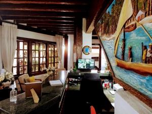 a living room with a large painting on the wall at Pousada dos Veleiros in Nova Almeida