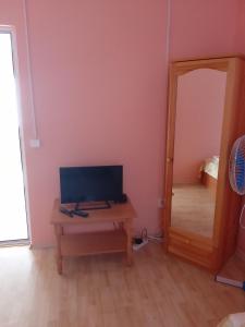 a room with a desk with a television and a mirror at Къща бунгало Градината in Krapets