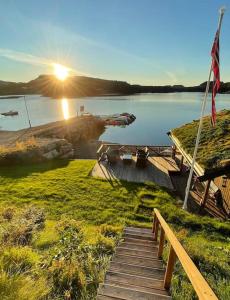 a wooden pathway leading to a lake with a flag at Nybygd hytte ved sjøen in Øygarden