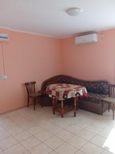 a living room with a table and a couch at Къща бунгало Градината in Krapets