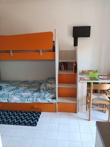 Un dormitorio con una litera y un escritorio. en Valbella, en Bibione