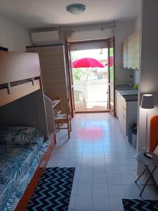 Una habitación con una cama y una cocina con sombrilla. en Valbella, en Bibione