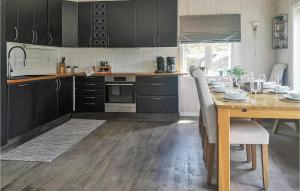 a kitchen with a wooden table and a dining room at Stunning Home In Hebnes With Kitchen in Hebnes