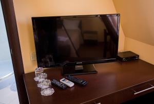 a television sitting on a table with remotes at Mіnі Gotel Pozitiv in Horodets'ke