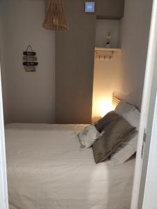 a bedroom with a white bed with a lamp at Le Palais du Tropique in Juan-les-Pins