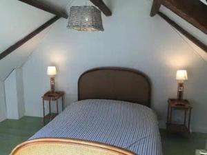 una camera da letto con un letto con due lampade su entrambi i lati di Au coin du loup, monts de Flandres, Zwarteberg a Saint-Jans-Cappel